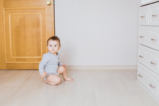 One year old cute baby boy sitting on rustic wooden floor photo