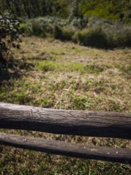 Aged wooden fence bordering grassy meadow near aosta, capturing rustic italian countryside with autumn's muted golden hues targnod photo