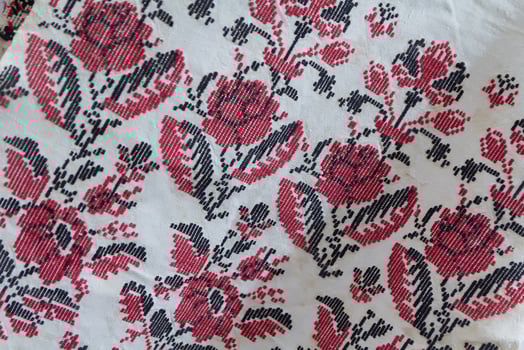 Red and white ukrainian embroidery on white background close-up, texture of ukrainian cross embroidery, flowers ukrainian ornaments photo