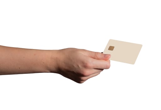 Bank card held in hand, showcasing a beige plastic design. Customer using the card for electronic photo