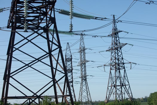 High Voltage Power Lines Stretch Across a Clear Blue Sky photo