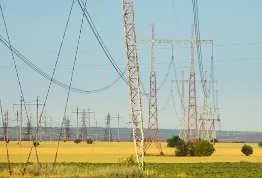 Series of High Voltage Pylons Spanning the Horizon on a Sunny Day photo