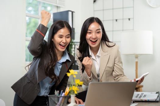 Celebrating Success in Business. Two women expressing joy over a successful project outcome. photo