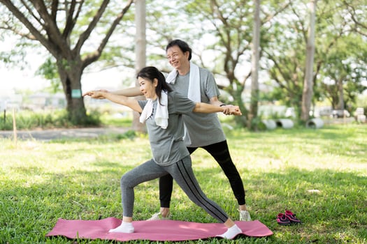 Couple practicing yoga poses together in the park photo