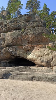 Cave entrance in a rock formation with trees on top. Burabay, Borovoe, Kazakhstan photo