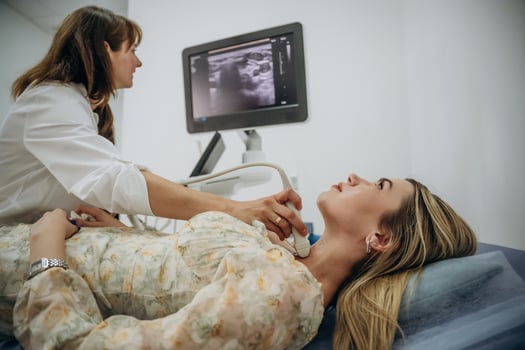 Woman, is lying down and undergoing ultrasonic test of the thyroid gland photo