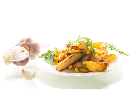 Home food - aromatic potatoes from the oven on a white background photo