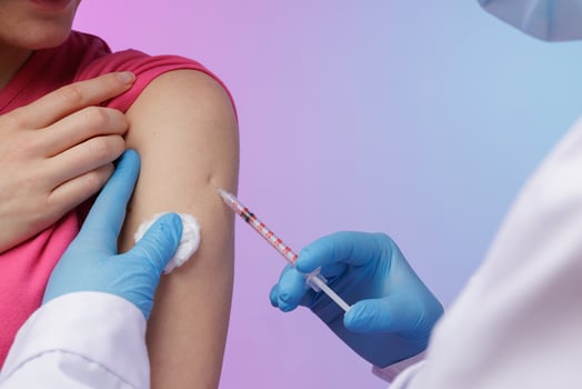 Close up of a healthcare worker administering a vaccine injection into a patient upper arm, symbolizing protection, medical care, and immunization against viruses. photo