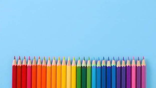 Colored pencils on light blue background photo