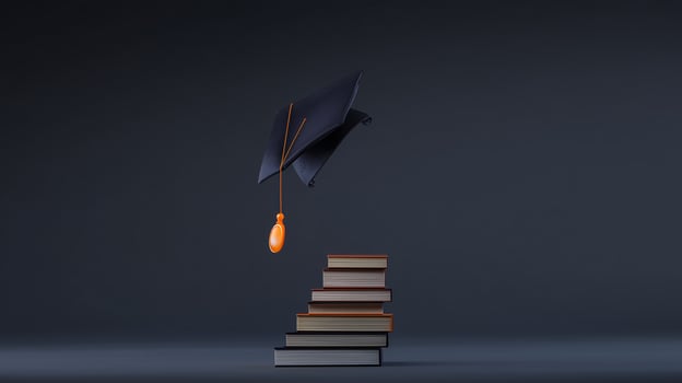 A graduation cap is sitting on top of a stack of books photo