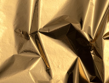 Gold foil background with crinkled texture. Wrinkled, creased, and crumpled tinfoil material photo