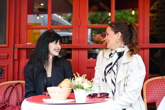 Friends talking and smiling at a Paris street cafe photo