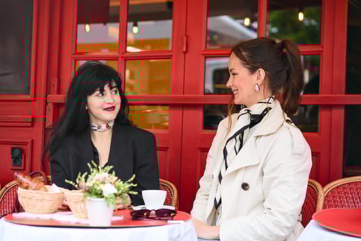 Women talking over coffee at a red Parisian cafe photo