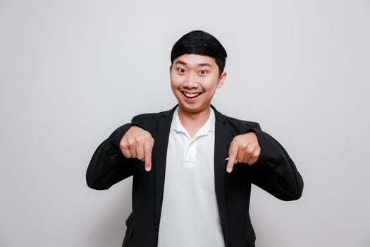 Cheerful business man gesture point finger down isolated photo