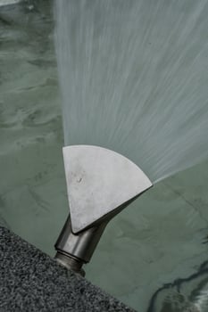 Fountain nozzle disperses water fountain, water close-up photo