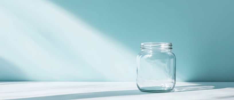 Blue background with a clear glass jar photo