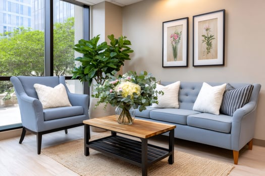 Modern waiting room with blue sofa, armchair and coffee table featuring fresh flowers photo