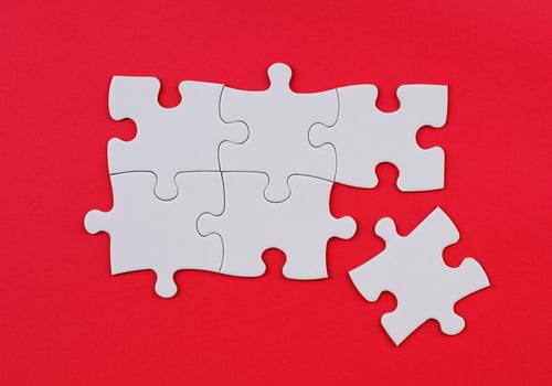 White Puzzle Pieces on Red Background. Missing Piece Concept. Stock photo. photo