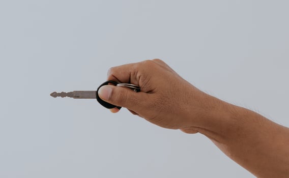 Hand holding a motorcycle or house key isolated over a white background. photo