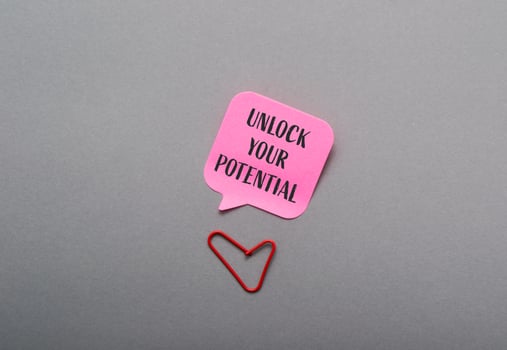 Pink sticky note with the words Unlock Your Potential written on it photo