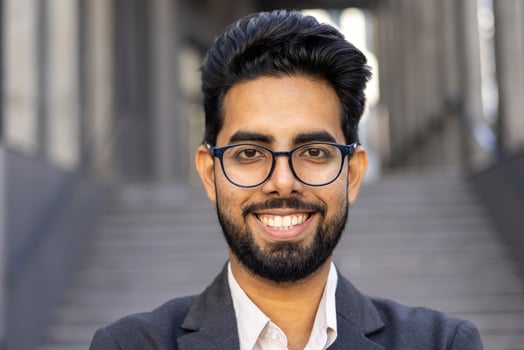 Close up portrait of businessman, man in business suit smiling and looking at camera, successful investor banker outside office building. photo