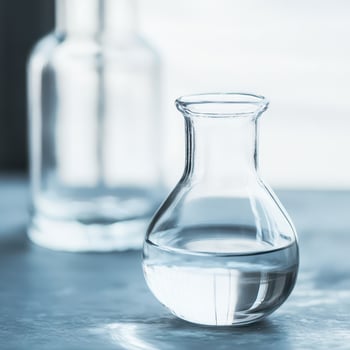 Clear glass vessel with water on a table photo