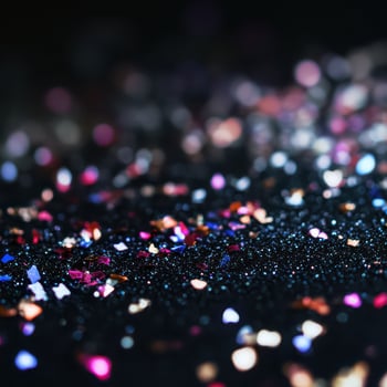 Colorful glitter scatter on dark surface photo