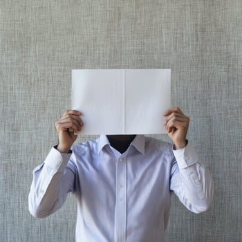 Person holding blank paper in front of their face photo