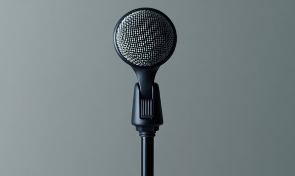 A microphone is standing upright on a grey background photo