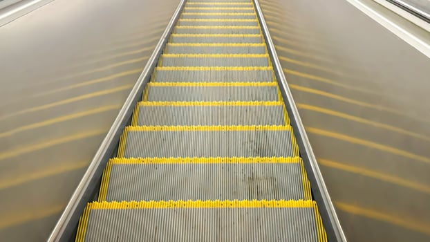Empty Yellow-Lined Escalator Steps in Urban Subway Station photo