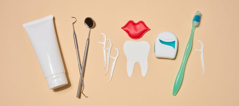 Set of tools and products for oral hygiene, toothpaste, dental floss, dental instruments, decorative elements in the form of paper teeth and red lips, photo