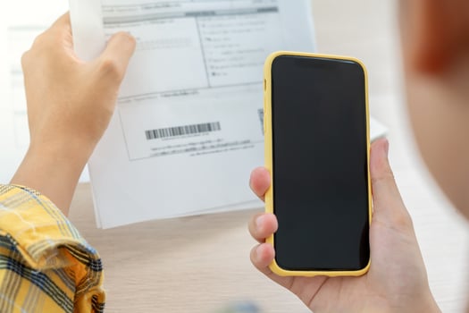 woman use phone scan barcode or QR codes to pay credit card bill after receiving document invoice. payment, receive, paying electricity. digital payments, technology, scanning, financial transactions photo