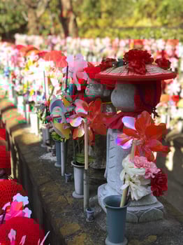 Jizo statues at a temple in Japan, symbol for miscarried children at day with sun photo