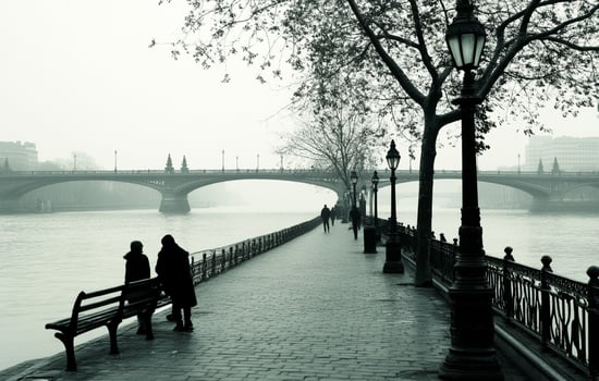 Two people are sitting on a bench near a river photo