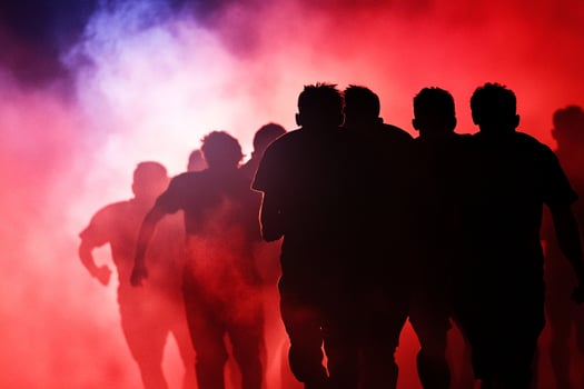 Silhouettes of people walking in a red and blue smoke photo