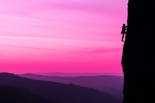 A man climbing a mountain at sunset photo