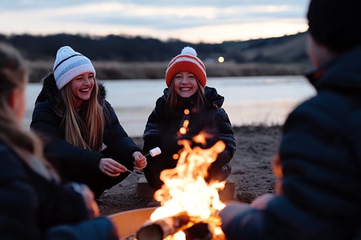 Three girls sitting around a campfire with a marshmallow photo