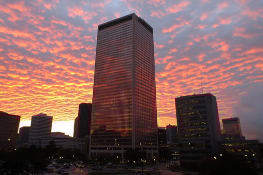 A tall building with a sky filled with clouds photo