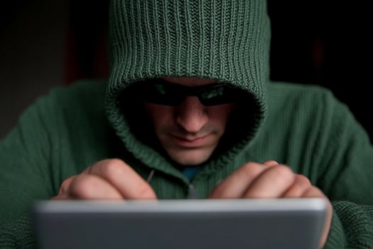 A man in a hoodie is using a tablet photo