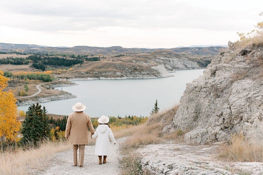 A family walks down a path overlooking a lake photo