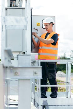 Electrical engineer inspect the electrical systems at the equipment control cabinet. Installation of modern electrical station, vertical photo. photo