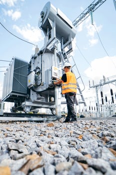dult electrical engineer inspect the electrical systems at the equipment control cabinet. Installation of modern electrical station, vertical photo