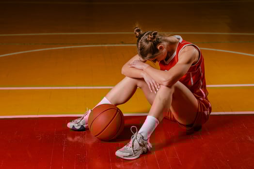 Dejected Female Basketball Player on Court photo