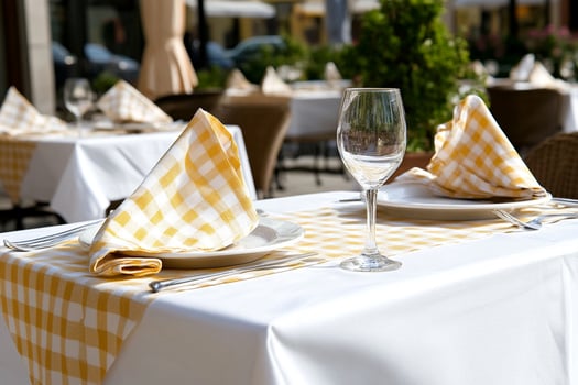 A table with a white tablecloth and yellow checkered napkins photo