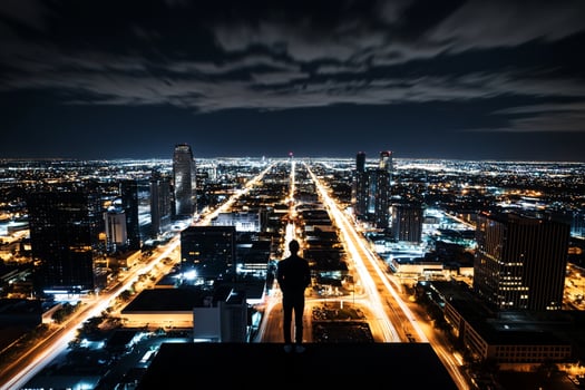 A man stands on top of a building at night photo