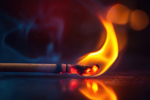 Burning match with smoke and orange flames creating warmth photo