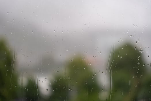 Raindrops on window with blurred view of trees and overcast sky in Bergen, Norway. photo