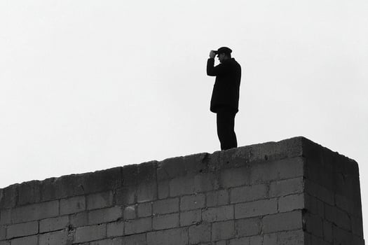 A man standing on top of a brick wall photo