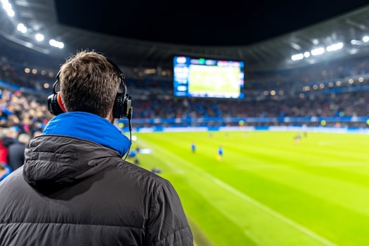 A man in a jacket is watching a soccer game photo