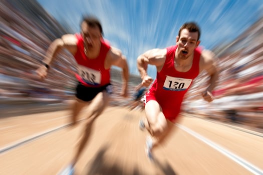 Two men running on a track with blurry motion photo